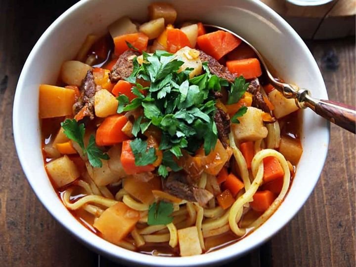 Bowl of lagman noodle soup with beef, potato and carrot