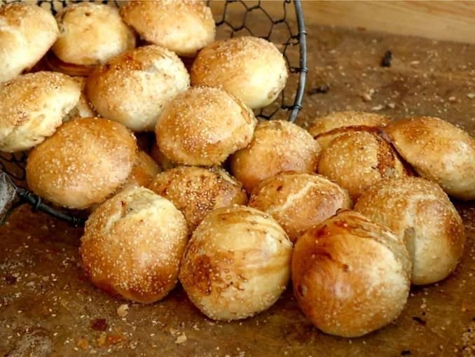 Basket of freshly baked samsa pastries with sesame seeds